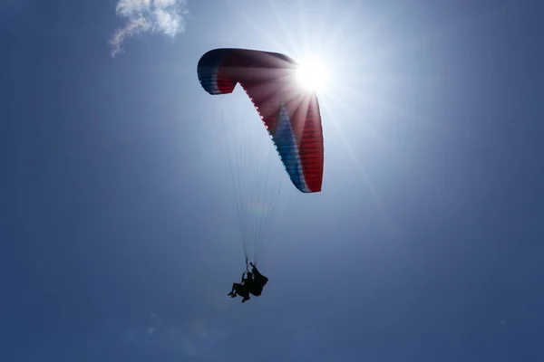 Une Silhouette Parapentes Tandem Avec Parachute Rouge Volant Travers Soleil — Photo