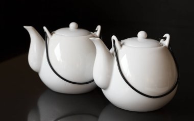 Siyah arka planda beyaz su ısıtıcısı veya çay kapları