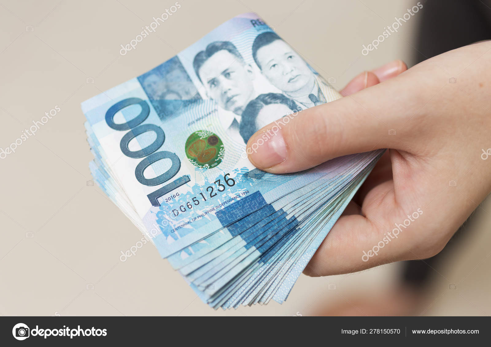 手里拿着折叠成捆的蓝色货币现金一千菲律宾比索支付账单或获得薪水付款日——图库图片© aldarinho #278150570
