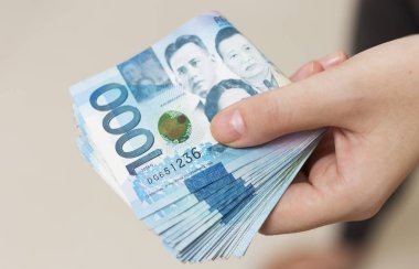 El bin Filipinler peso nakit mavi para katlanmış demet tutarak. Rüşvet vermek, faturaları ödemek ya da maaş almak. Ödeme günü!