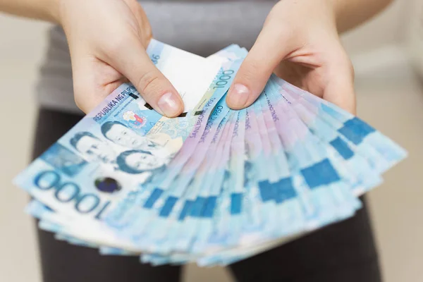 Eller maaş veya ödeme paketi bin filipinler peso nakit sanki zengin olmak tutarak. Gösteriş gösterin, faturaları ödeyin veya rüşvet verin.
