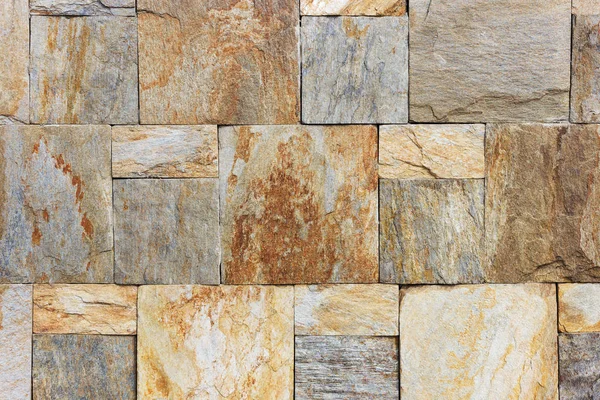 Texture of the brown and grey wall made of square stone tile bricks