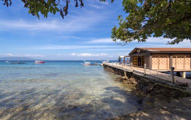 Deniz, mavi gökyüzü, palmiye, bungalov ve Beyaz plajda tekneler, Sabang, Puerto Galera, Filipinler. Popüler turistik ve dalış noktası.