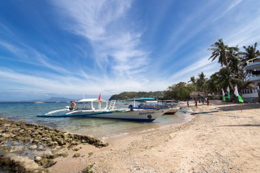 Sabang, Puerto Galera, Filipinler - 13 Ocak 2017: İskele denizi, mavi gökyüzü, palmiyeler ve tekneler. popüler turist ve dalış noktası.