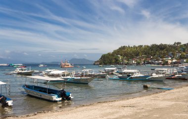 Sabang, Puerto Galera, Filipinler - 13 Ocak 2017: İskele denizi, mavi gökyüzü, palmiyeler ve tekneler. popüler turist ve dalış noktası.