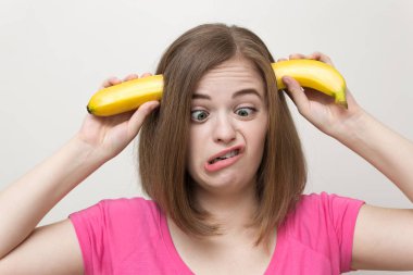 Elinde sarı muz ile gülümseyen beyaz kadın kız portresi komik yüz yapma. Sağlıklı yaşam tarzı, meyve vejetaryen diyet.