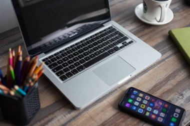 Manila, Filipinler - 5 Ekim 2019: Çalışma alanı masa üstü görünümü: dizüstü bilgisayar klavye, telefon ve bir bardak kahve. Sosyal medya molası!