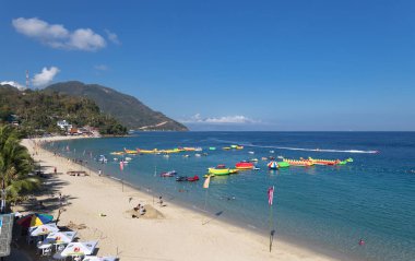 Puerto Galera, Filipinler - 4 Nisan 2017: Deniz, mavi gökyüzü, palmiyeler, turistler ve tekneler White Beach, Sabang.
