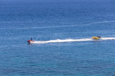 Puerto Galera, Filipinler - 4 Nisan 2017: Denizde jet ski süren bir adam, White Beach yakınlarında uçan balıklar
