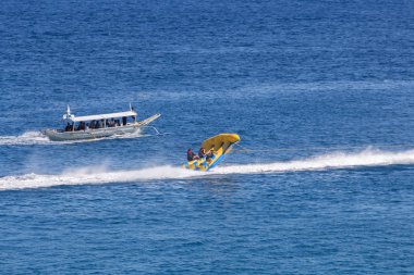 Puerto Galera, Filipinler - 4 Nisan 2017: Denizde jet ski süren bir adam, White Beach yakınlarında uçan balıklar