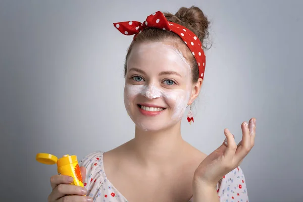 若い白人女性の女の子を笑顔面白い顔で白い日焼け止め化粧水クリームを入れています 夏のUv保護コンセプト ストック画像