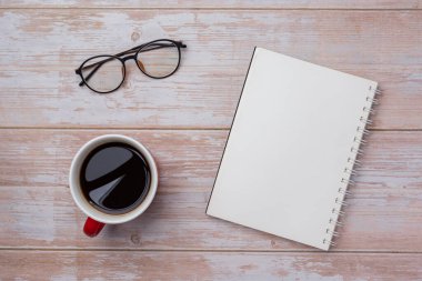Boş sarmal defter, kahve fincanı ve bardakların üstünde.