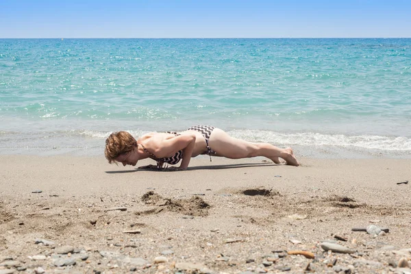 Genç kadın pratik yoga deniz kıyısında