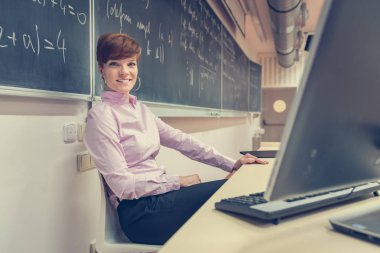 Genç öğretmen sınıf onun bilgisayar üzerinde bir öğretim ders hazırlar