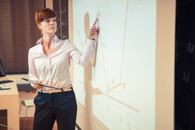 genç kız öğrenci ve sonuçları bir sınıfta bir kara tahta üzerinde bir grafik üzerinde gösterilen işadamı