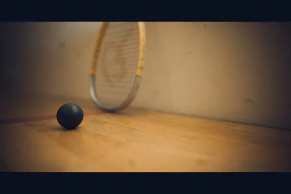 Squash bal op baan met squash racket klaar om te spelen — Stockfoto