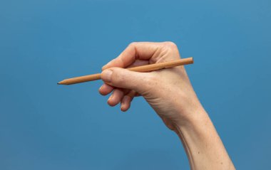 Genç kadın mavi arka planda eller gösteren. Eller ve tırnakların çekici sunumu