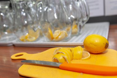 Buharda bardakta limon ile serinletici soğuk su. Sarı ahşap bir masada. Yemeğe hazırım. Sonraki bir bıçak meyve kesme sonra