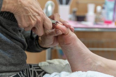 Kadın pedikür ve ayak masajı yapıyor. Sağlıklı bir yaşam tarzı için vücut bakımı ve rahatlama. Spa prosedürleri.