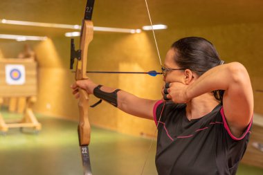 Okçuluk bir spor disiplini olarak salonda ve doğada çalıştırın. En iyi atış için rekabet hedeflere bir ok