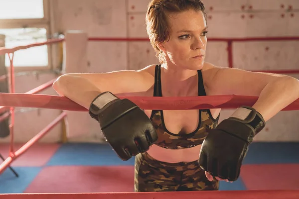 Hermosa mujer, luchadora mma en el gimnasio durante el entrenamiento. Preparándose para un partido en jaula dura — Foto de Stock