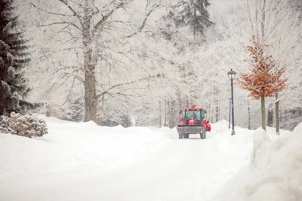Trator limpa estrada de neve no inverno — Fotografia de Stock