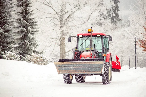 Tractor reinigt weg van sneeuw in de winter — Stockfoto