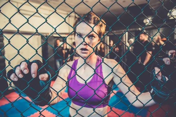 Hermosa mujer, luchadora mma en el gimnasio durante el entrenamiento. Preparándose para un partido en jaula dura. Sangre en la cara — Foto de Stock