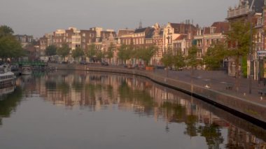 Yazın gündoğumunda tipik evleri olan muhteşem Amsterdam kanalları. Yel değirmeni ve köprüleri kaldırmak