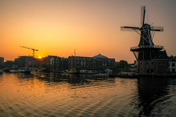 Zonsopgang over een kanaal bij een windmolen in Nederland Amsterdam — Stockfoto