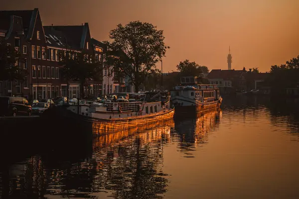 Sonnenaufgang über einem Kanal an einer Windmühle im niederländischen Amsterdam. Schiffe ankern im Hafen — Stockfoto