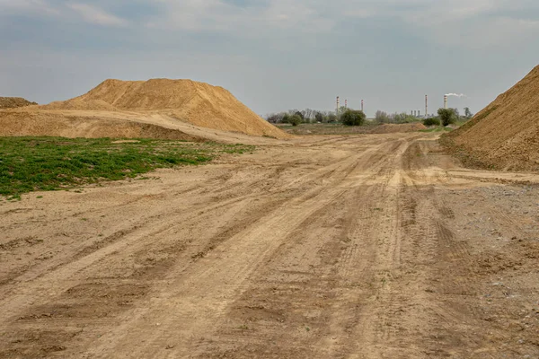 Escavatore riassume il terreno in cantiere nella stagione estiva secca — Foto Stock