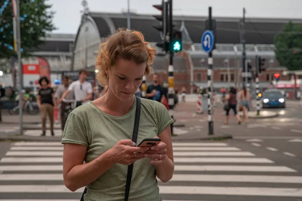 若い女性が携帯電話で旅をし、世界への関心の新しい場所を発見する。スマートフォンでの写真とナビゲーション — ストック写真