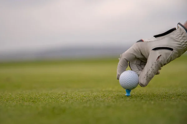 Een golfspeler bereidt de bal voor om op de golfbaan te worden afgevuurd — Stockfoto