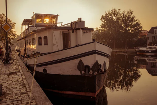 Boat anchored on a canal in Amsterdam at sunrise — Stockfoto