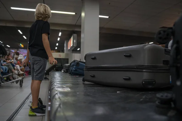 남자 아이 가 공항에 도착하자마자 짐을 기다리고 있습니다 — 스톡 사진