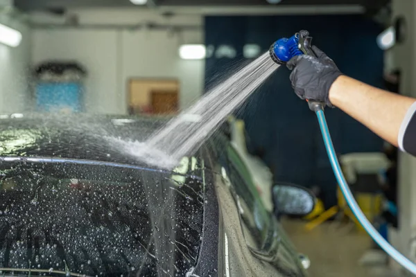 Lavado de autos a mano en el garaje. ducharse con agua —  Fotos de Stock