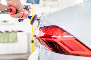 Cilalayarak arabanın tamirini ve bakımını yapıyor. Koruma ve parlatıcı için özel bir seramik hazırlama uygulaması