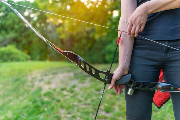 Estirar una flecha en un arco durante el tiro con arco en la naturaleza —  Fotos de Stock