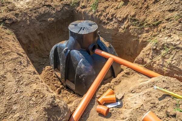 Plastic pipes in the ground for draining rainwater into the container — Stock Photo, Image