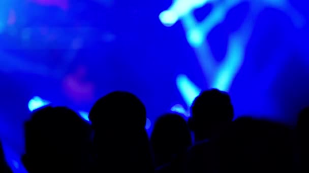Σιλουέτες του θεατή στη συναυλία φωτίζεται από χρωματιστά φώτα από τη σκηνή — Αρχείο Βίντεο