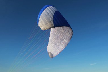 Pilot yeni gelen yamaçparaşütü yukarı kaldırın ve mavi-beyaz paraplane tutun yere eğitimli