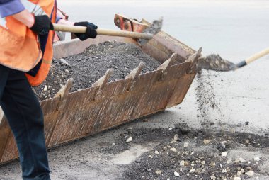 Kısmi yol onarım ile eski kapağının çukurları ve yama sitede kaldırma. yol işçileri eski asfalt kırıntı yol çukurları traktör Kepçe atmak