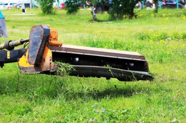 Meme kentsel çimenler üzerinde çim mows bir traktör