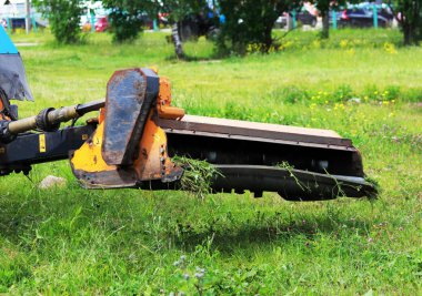 Meme kentsel çimenler üzerinde çim mows bir traktör