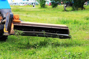 Meme kentsel çimenler üzerinde çim mows bir traktör