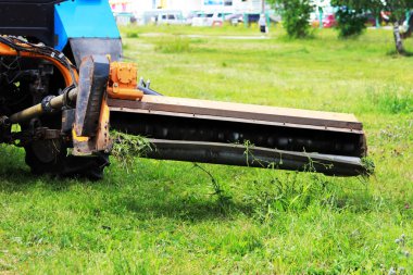 Meme kentsel çimenler üzerinde çim mows bir traktör