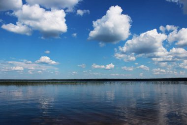 Beyaz bulutlar sudaki yansıması ile yaz aylarında göl Vysokinskoye. Leningrad Region, Rusya Federasyonu