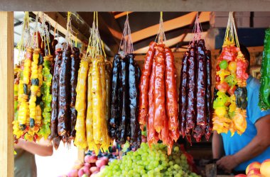 Cevizli sucuk. Geleneksel Gürcü ev yapımı tatlılar fındık, ceviz, üzüm suyu, şeker, buğday unu mısır unu tatlım. Tatlı Karadeniz yakınındaki setin yakınındaki pazarda satılmaktadır. Kırım Cumhuriyeti. Çekim röportaj