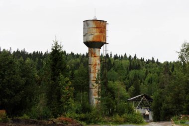 Eski paslı su kulesi, ormanın yakınında merdiveni var..